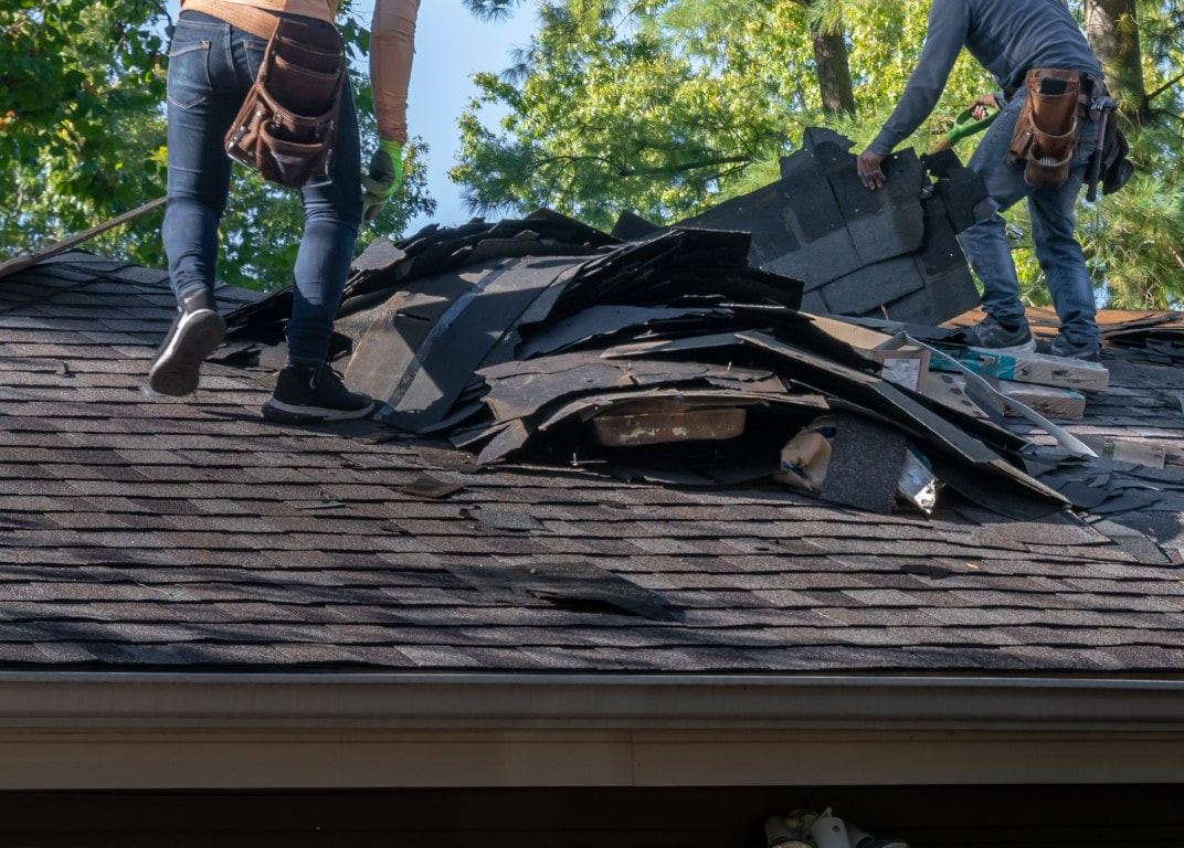 An image of two persons working on a damage roof replacement
