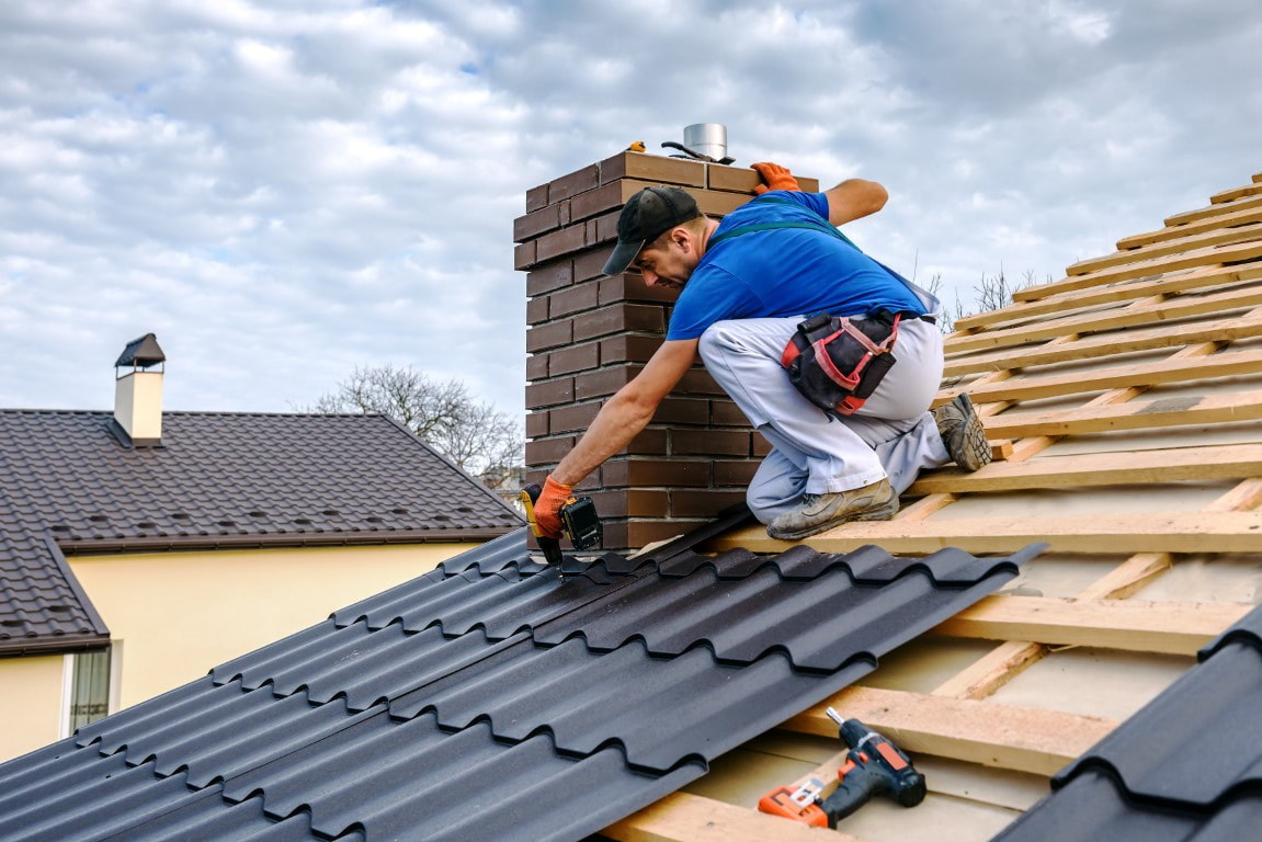 A picture of a man applying roof tiles for a roofing company