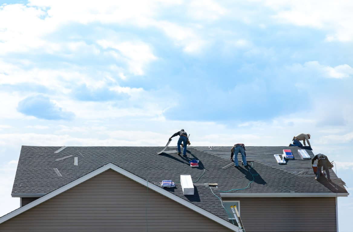 An image of persons working on a roof maintenance service